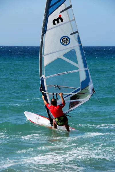 Uomo windsurf al largo della spiaggia di Valdevaqueros, Tarifa, Spagna . — Foto Stock