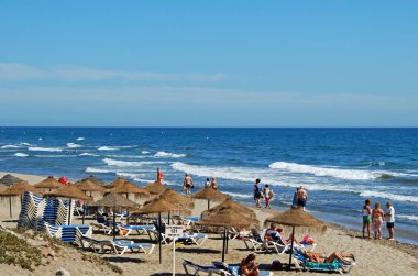 Turistler rahatlatıcı yükseltilmiş görünümünü Playa de las Canas Beach, Marbella, İspanya.