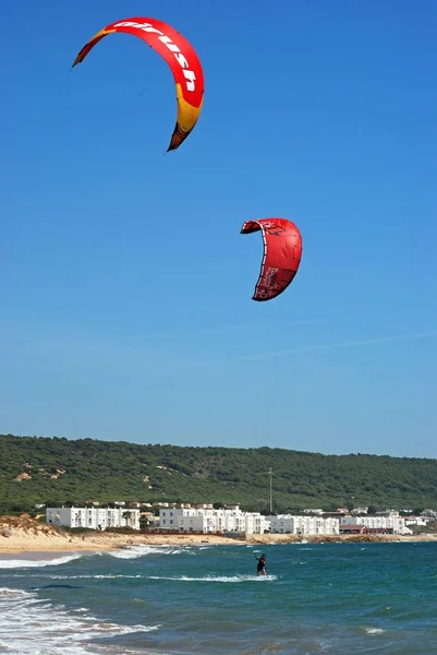 Kitesurfers avec la plage et les bâtiments municipaux à l'arrière, Cabo Trafalgar, Espagne . — Photo