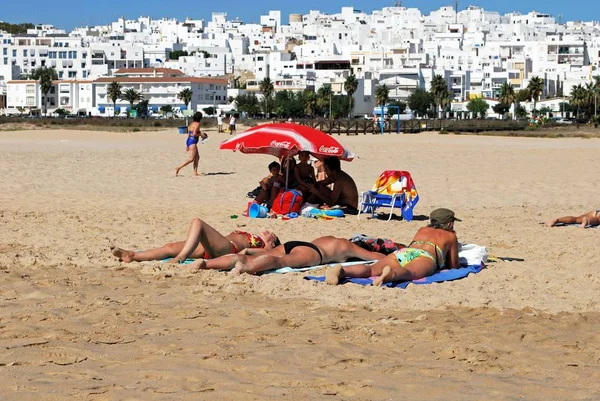 Turisták pihentető a strandon, a fehér város, Conil de la Frontera, Spanyolország felé néző. — Stock Fotó