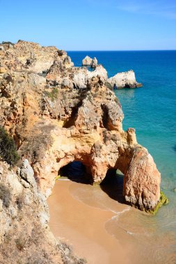 Ön planda küçük bir tenha plaj ile kayalıkların yükseltilmiş görünümü, Praia da Rocha, Portimao, Portekiz.