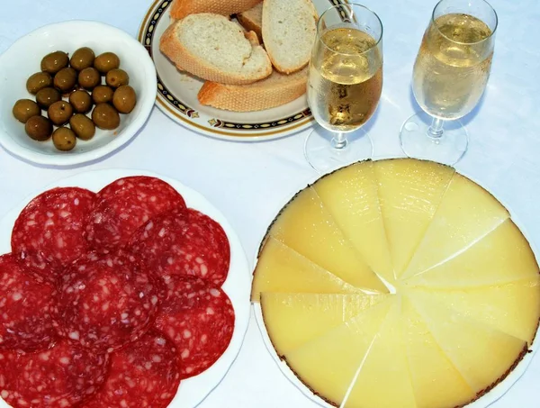 Eine Auswahl an spanischen Tapas wie Manchego-Käse, grüne Oliven und Salami mit zwei Gläsern Fino-Sherry. — Stockfoto