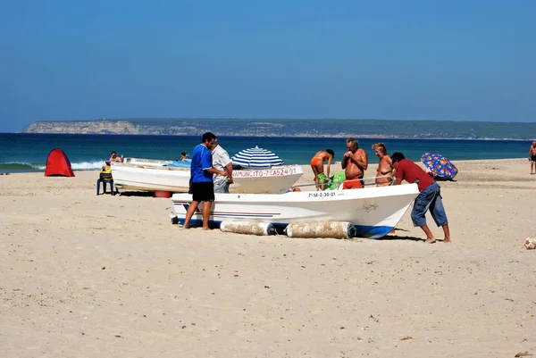Drewniana łódź rybacka na plaży z turystami, Zahara de los Atunes, Hiszpania. — Zdjęcie stockowe