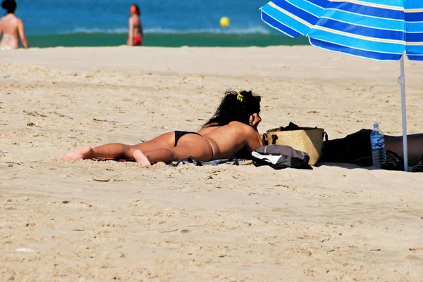 Woman sunbathing by a parasol on the beach, Zahara de los Atunes, Spain. — 스톡 사진