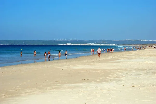 Dvojice odpočívám na pláži s výhledem na pobřeží, Zahara de los Atunes, Španělsko. — Stock fotografie