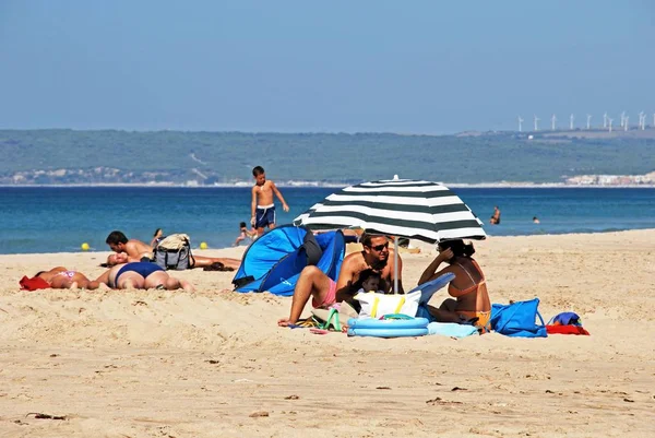 Turistas relajados en la playa con vistas hacia la costa, Zahara de los Atunes, España . — Foto de Stock