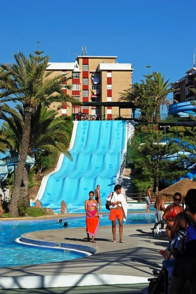 Tobogán acuático y piscina en el parque acuático con los turistas disfrutando del entorno, Fuengirola, España . — Foto de Stock