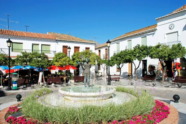 Fontana in Plaza de Espana circondata da graziosi fiori con caffè e negozi sul retro, Benalmadena Pueblo, Spagna . — Foto Stock