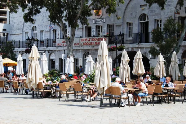 Turistas relajándose en cafeterías de pavimento en la Plaza Grand Casemates, Gibraltar . — Foto de Stock