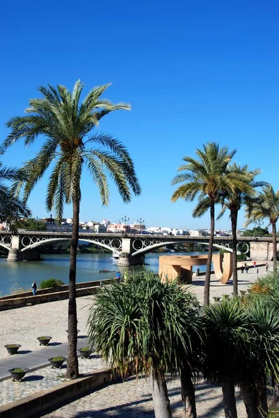 Vista a lo largo del río Guadalquivir con el puente de Triana en la parte trasera, también conocido como el puente Isabel II, Sevilla, provincia de Sevilla, Andalucía, España . —  Fotos de Stock