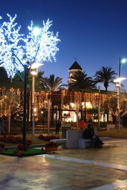 Alacakaranlıkta arka Carmen Kilisesi çan kulesi ile bir plaza Noel süslemeleri, Fuengirola, İspanya.