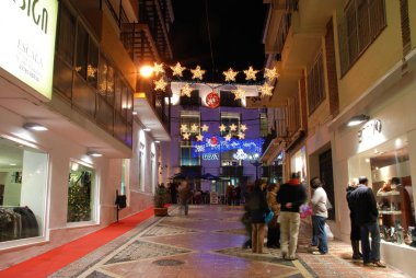 Gece bir şehir merkezi alışveriş caddesi boyunca Şenlikli Noel süslemeleri, Marbella, İspanya.