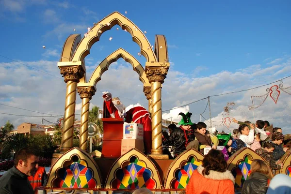 Desfile de Reyes Magos con Melchor sentado en su carruaje lanzando dulces al público, La Cala de Mijas, España . —  Fotos de Stock