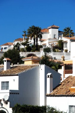 Yamaçta beyaz badanalı daire ve villaların manzarası, Riviera del Sol, İspanya.