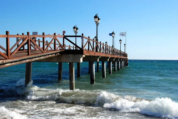 Pier de madeira que conduz ao mar da praia de Daitona, Marbella, Espanha . — Fotografia de Stock