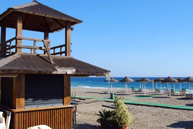 Sahilde gözetleme kulesi ve şemsiyeler, Daitona Beach, Marbella, İspanya.