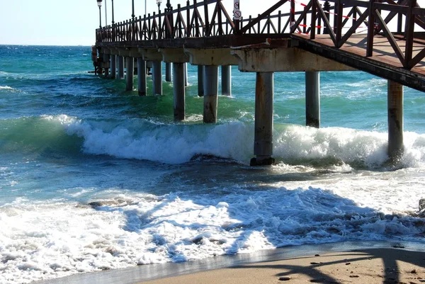 Pier de madeira que conduz ao mar da praia de Daitona, Marbella, Espanha . — Fotografia de Stock