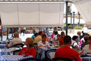 Şehir merkezinde gölgeli bir kaldırım kafede rahatlatıcı Turistler, Ronda, İspanya.