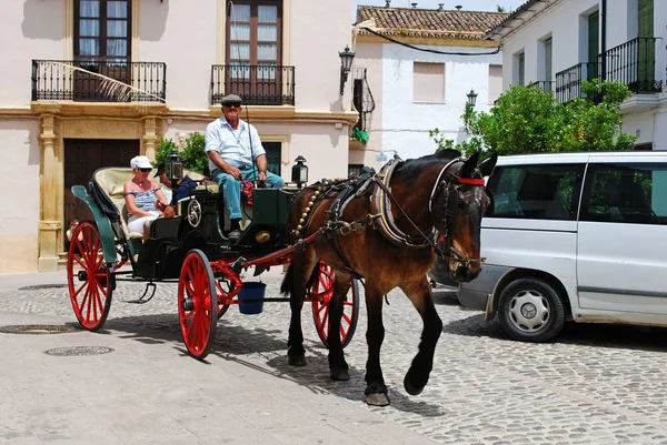 Koń ciągnięte wózek przewożący turystów na starym mieście, Ronda, Hiszpania. — Zdjęcie stockowe