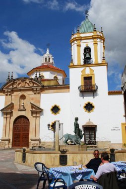 Ön planda bir kaldırım kafede insanlarla Plaza del Socorro Socorro Parish kilise görünümü, Ronda, İspanya.