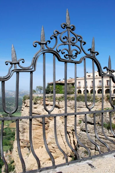 Wrought iron fence panel on the New Bridge with the Parador Hotel to the rear, Ronda, Spain. — Stock Photo, Image