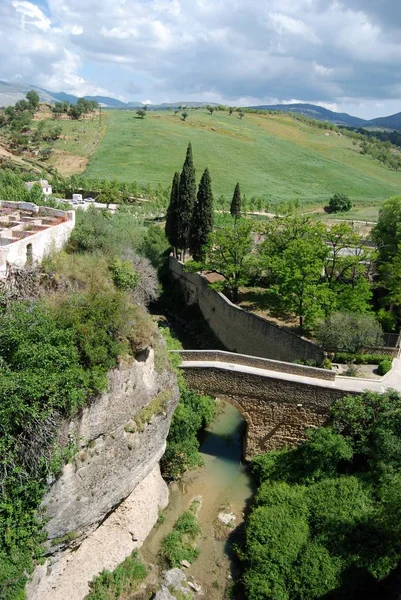 Elevated view of the San Miguel bridge crossing the ravine with views towards the countryside and mountains, Ronda, Spain.