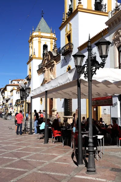 Turyści relaksując się w kawiarniach na placu Plaza Socorro z centrum parochial (Centro parroquial) do tyłu, Ronda, Hiszpania. — Zdjęcie stockowe