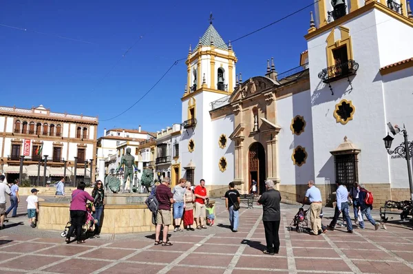Turyści relaksując się przy fontannie Herkulesa z Kościołem Socorro z tyłu w Socorro Plaza, Ronda, Hiszpania. — Zdjęcie stockowe