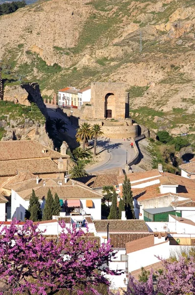 Torre moresca con alberi di fiori rosa e case in primo piano, Antequera, Spagna . — Foto Stock