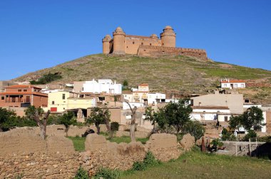 Tepedeki şatonun manzarası ön planda kasaba binaları, La Calahorra, İspanya.