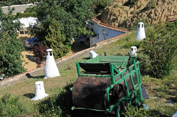 동굴에 있는 집들 과 굴뚝들 과 농장 기계들 이 스페인, 구아 디슈, 투 글로 디테 지역의 앞부분에 있는 굴뚝들 사이에 있는 농장 기계들. — 스톡 사진