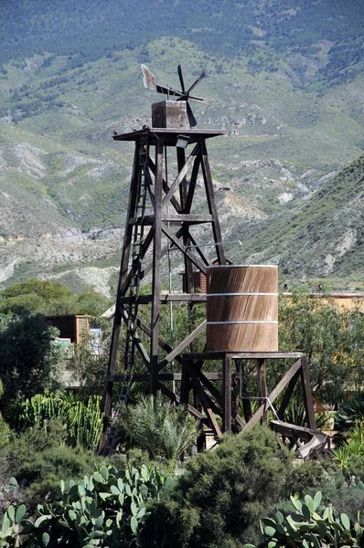 Bomba de água de madeira em Fort Apache em Mini Hollywood com montanhas para trás, Tabernas, Espanha . — Fotografia de Stock