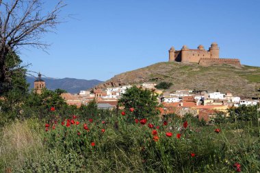 Tepedeki şatonun manzarası ön planda kasaba binaları, La Calahorra, İspanya.