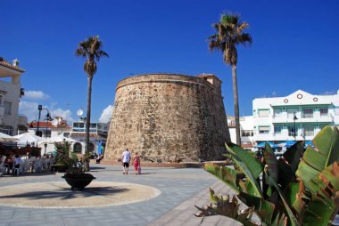 Plaza de Torreon 'daki eski gözetleme kulesi ve kaldırım kafeleri. Sahnenin keyfini çıkaran turistler, La Cala de Mijas, Malaga Eyaleti, Endülüs, İspanya ve Batı Avrupa.