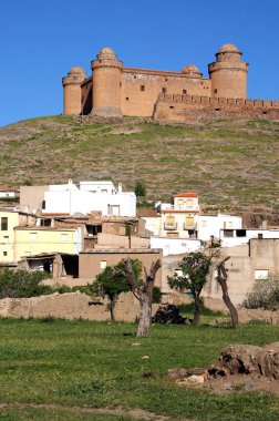La Calahorra, Granada Eyaleti, Endülüs, İspanya, Avrupa 'da şehir binalarının bulunduğu tepedeki şatonun manzarası.