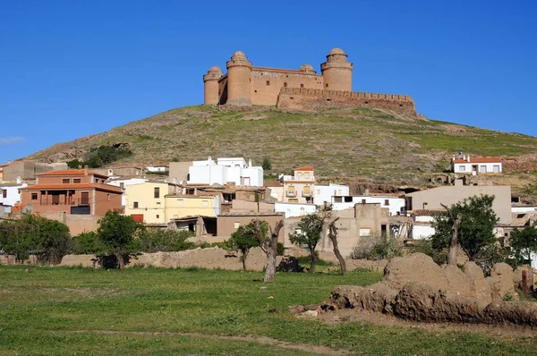 La Calahorra, Granada Eyaleti, Endülüs, İspanya, Avrupa 'da şehir binalarının bulunduğu tepedeki şatonun manzarası.