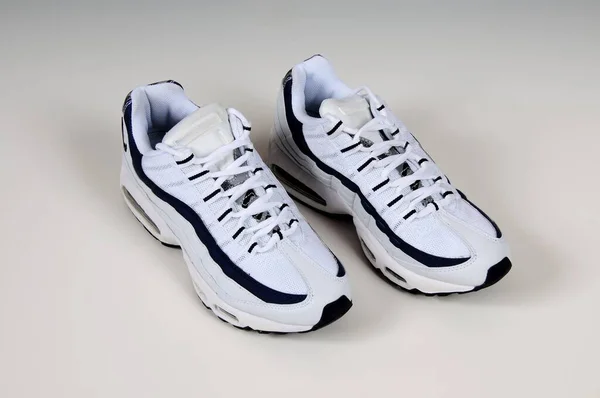 A pair of  white sports Trainers with navy blue trim