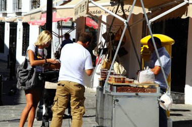 MIJAS, İspanya - 25 Ağustos 2010 - Köy merkezindeki Mijas, Malaga Eyaleti, Endülüs, İspanya, 25 Ağustos 2010 'da bal kaplı fındık alan çift