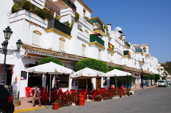 BENAHAVIS, SPAIN - JUNE 28, 2010 - Pavement cafe and apartments along a village street, Benahavis, Malaga Province, Andalusia, Spain, June 28, 2010