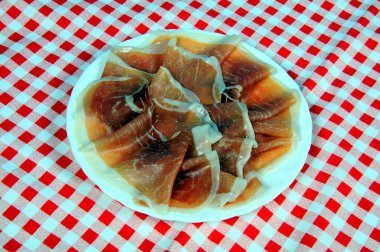 Jamon Serrano (tedavi edilmiş jambon) Endülüs, İspanya ve Batı Avrupa 'da beyaz bir tabakta hizmet verdi..