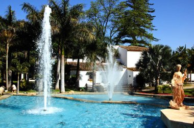 TORREMOLINOS, SPAIN - 13 Nisan 2011 - Arkada değirmen ve palmiye ağaçları, Molina de Inca; Torremolinos; İspanya, 13 Nisan 2011