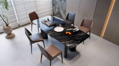 An elevated shot of an elegant dining space, showcasing a stunning black marble-like table and stylish leather chairs