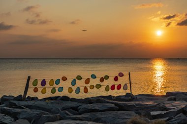 gün batımı ve renkli balonlar deniz kenarındaki halatlar üzerinde