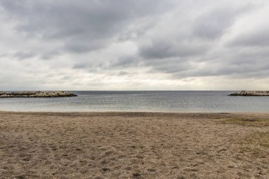 deniz, plaj, uçurumlar ve bulutlu gökyüzü