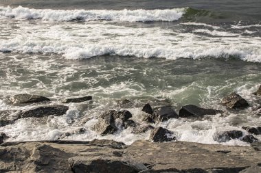 deniz ve plaj dalgalar yakınındaki kayalıklarla