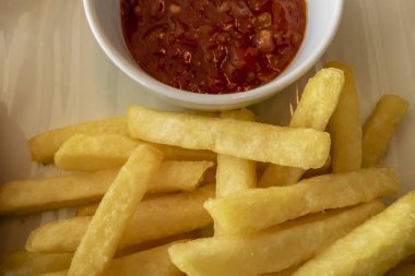 küçük beyaz tabakta kızarmış patates ve domates sosu kadar yakın.