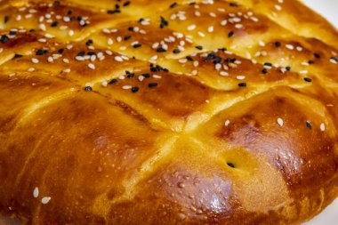 Türk ramazan ekmeği, susam ve siyah tohumile beyaz tabakta pide yakın