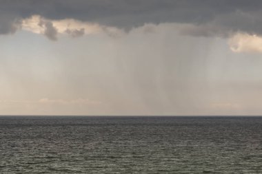gökyüzünde gizemli yağmur bulutları ve dalgalı deniz