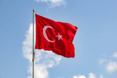 bayrak direğinde Türk bayrağını ve mavi gökyüzünü bulutlarla kapatın.