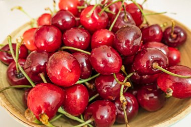 Beyaz arka planda kırmızı kirazları kaseye kapat